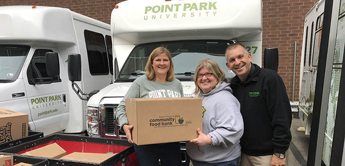 Heather Starr Fiedler, director of the Department of Community Engagement, Veronika Panagiotou, doctoral student, and Keith Paylo, vice president of student affairs and dean of students, prepare to stock Pioneer Pantry on campus.