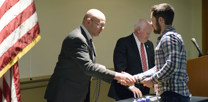 Pictured is Professor Sean Martin, Ph.D., inducting a student into the Alpha Phi Sigma Alpha Eta honor society for criminal justice and forensic science students. | Photo by Gracey Evans