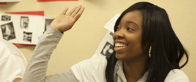 Pictured is a Point Park University student raising her hand in the classroom.