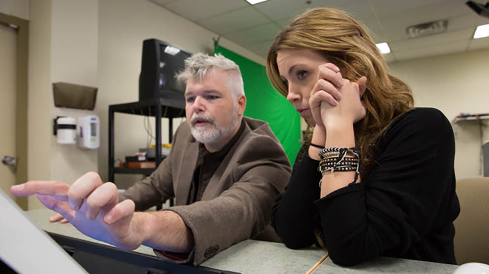 A Point Park student works with a representative from the Pittsburgh Aids Task Force on a project on campus. 