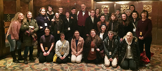 Students pose for a photo with their tour guide after a comprehensive tour of the iconic Radio City Music Hall.