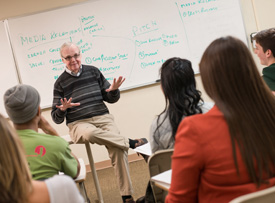 Pictured is Bob O'Gara, professor of public relations and advertising, teaching in the classroom. 