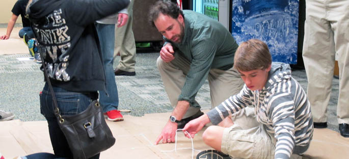 Pictured is Professor Matthew Pascal, Ph.D., working with high school students at Point Park's third annual Math Symposium. | Photo by Mary Cvetan