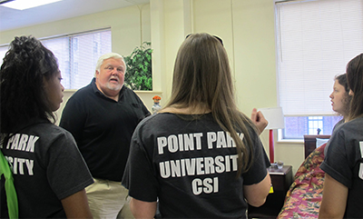 Pictured is Edward Strimlan, M.D., with students in the CSI House. Photo by Amanda Dabbs