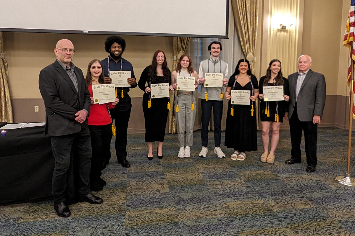 Pictured are Professor Sean Martin, Ph.D., students Alyssa Thomas, Nasir Galloway, Jaelyn Nye, Payton Moebius, Patrick Sullivan, Hannah Lanham, Elizabeth Getchey and Professor Richard Linzer, J.D., at the Alpha Phi Sigma National Honor Society ceremony.