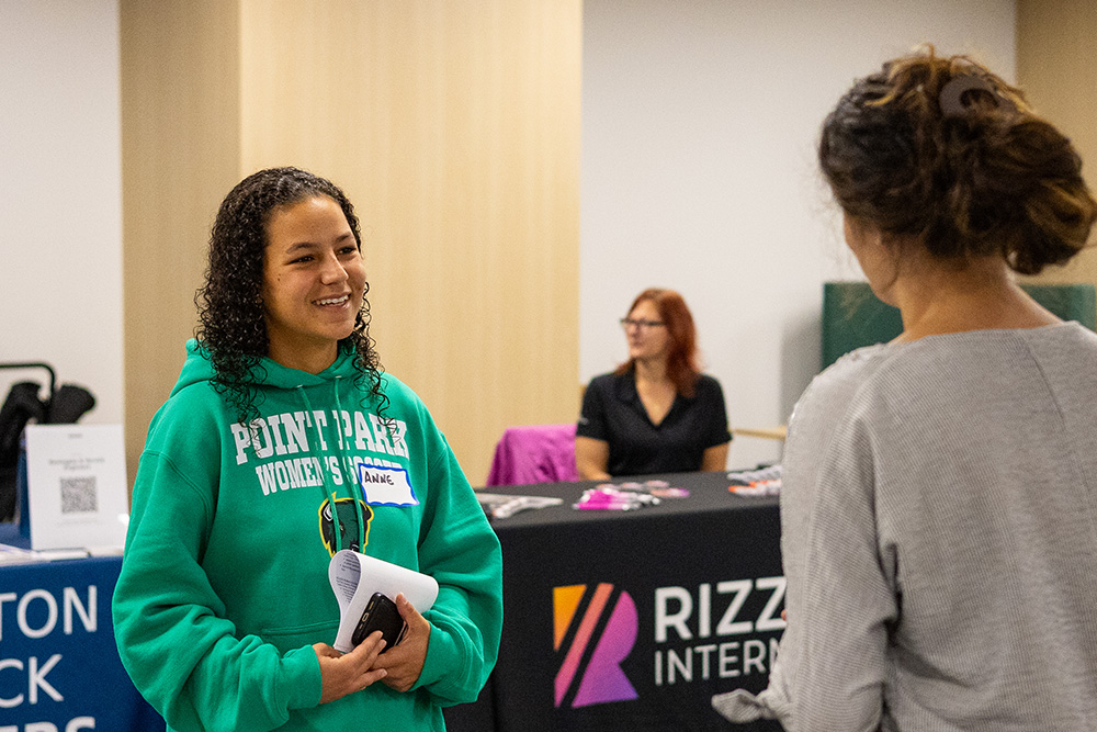 Pictured is a female student in a green Point Park University sweatshirt talking to a local engineering company representitive at the ESWP Career Fair on Oct. 7, 2025. 