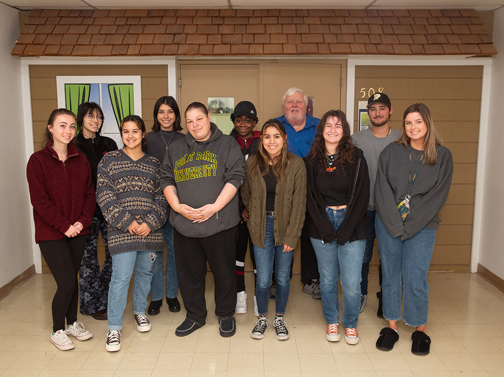 Pictured are Professor Edward Strimlan and students in front of the entrance to the CSI House. Photo by Randall Coleman.