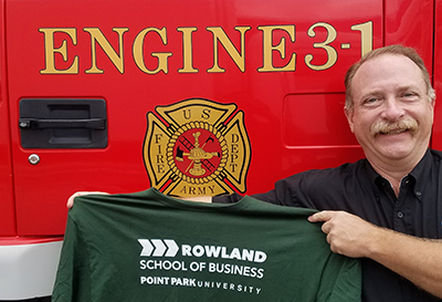 Pictured is Robert Skertich, Ph.D., in Japan with a Rowland School of Business shirt. Photo submitted by Skertich.
