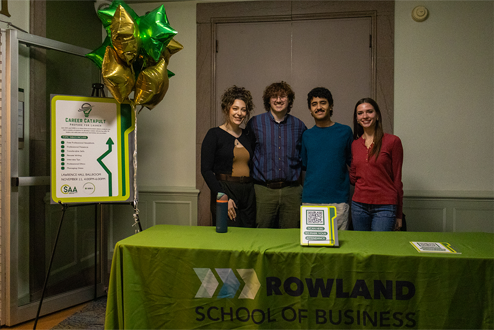 A group of students pose near a table for the Career Catapult event.