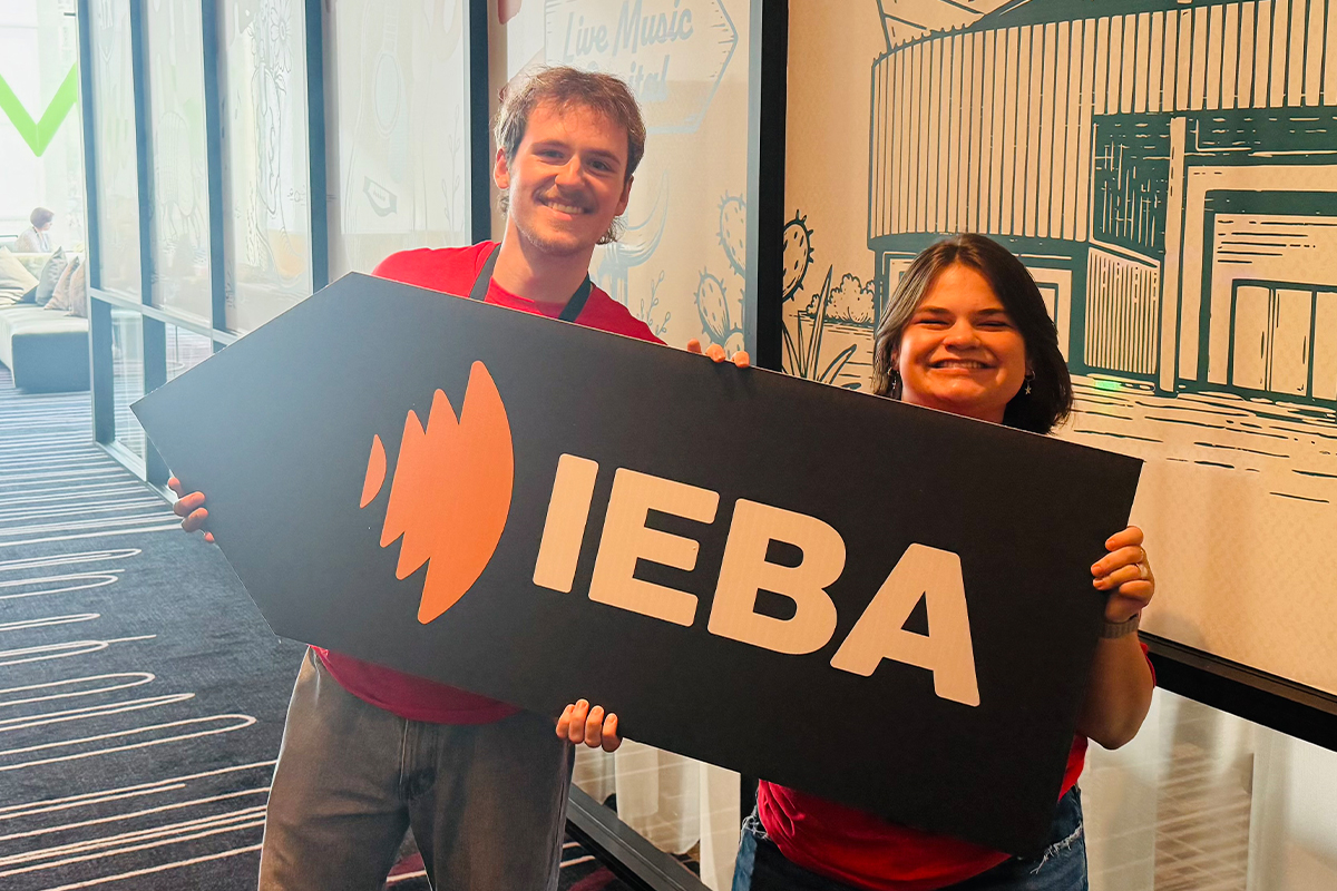 Students pose with a sign at the 2026 IEBA Conference.