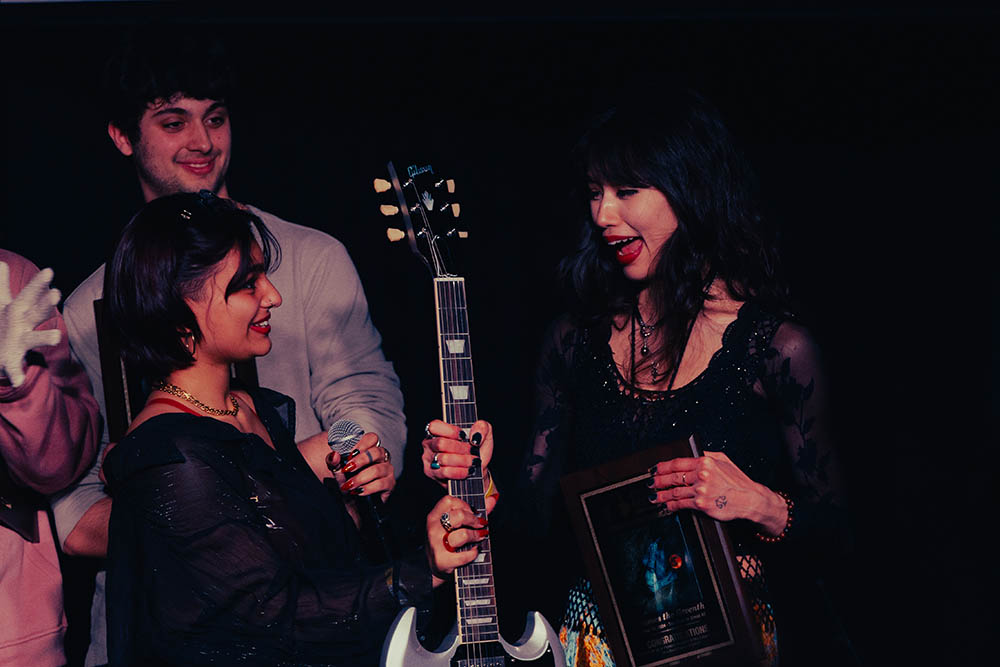 Pictured is Sandamini Sinley presenting Bethany Latham with a Gibson guitar at the 2024 Pioneer Star Showcase. Photo by Ethan Stoner.