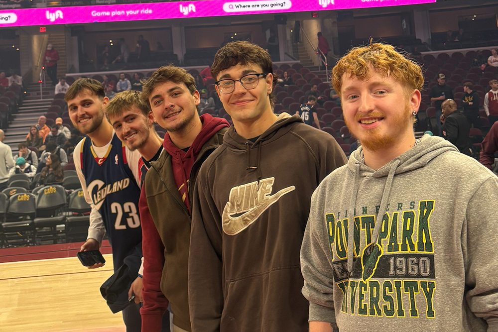 Students from Point Park University's Cavs Sales team pose for a photo on the Cavaliers basketball court.