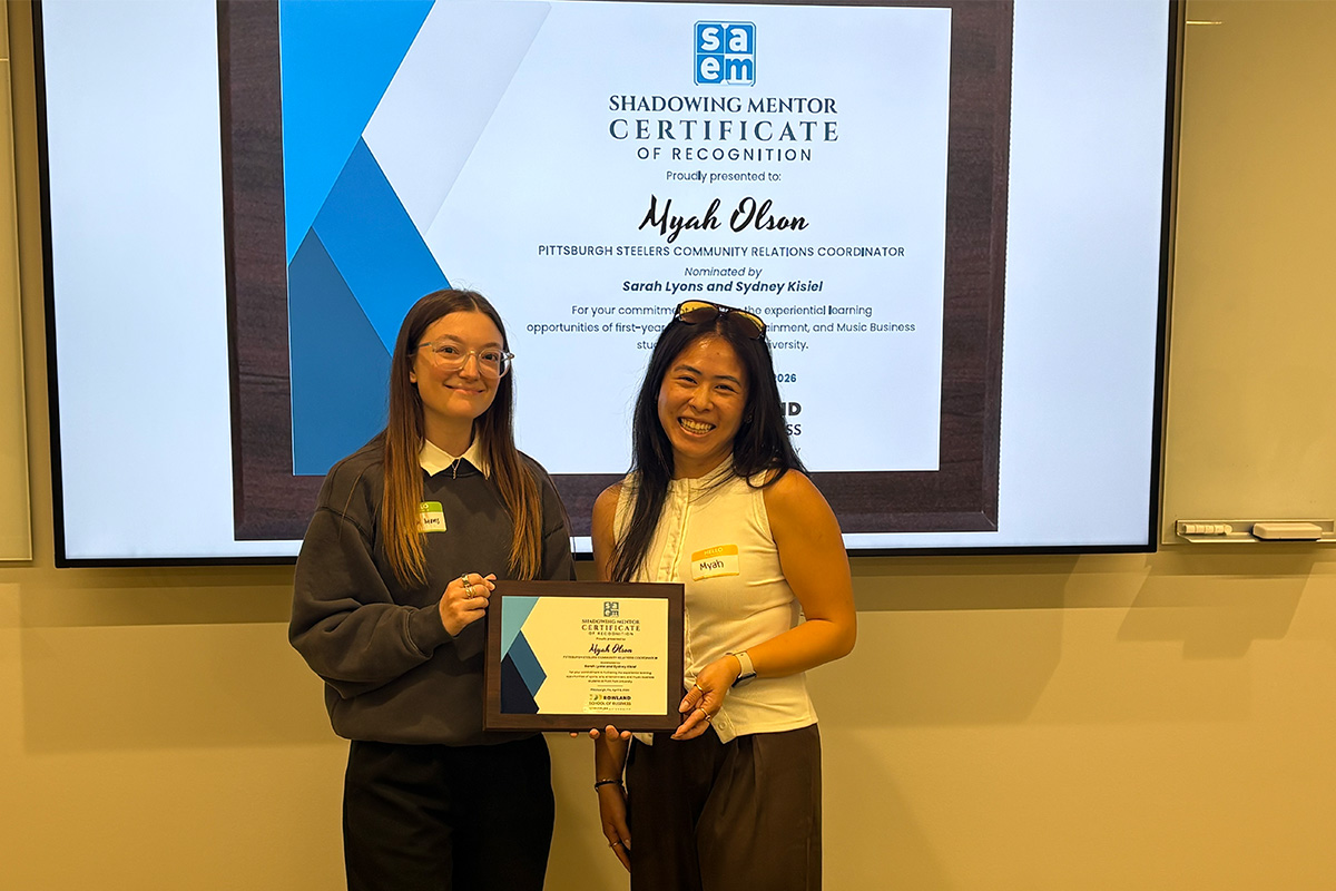 Srah Lyons, left, poses with Myah Olson, right, from the Pittsburgh Steelers, as she presents an award for the shadowing experience. Photo submitted.