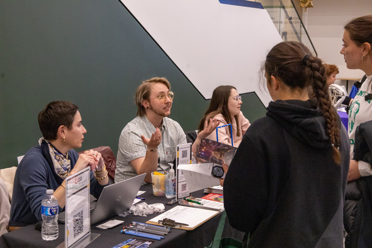 A student provides his resume to a recruiter.