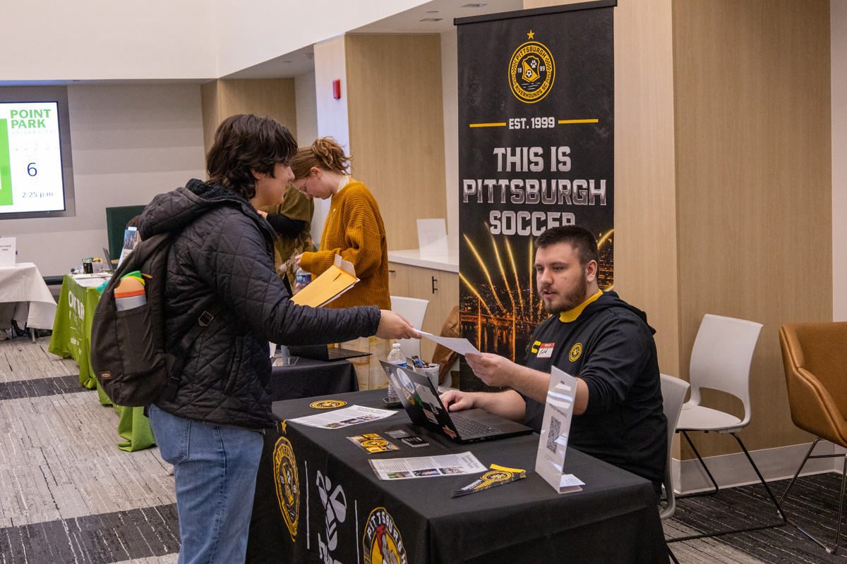 Students talk to a visitor about job opportunities in Pittsburgh.