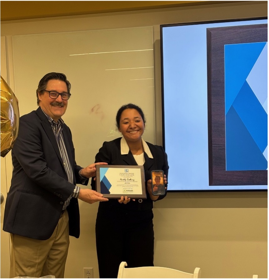 Bob Derda, left, poses with Maddy Sedberry, right, from Live Nation, as he presents an award for the shadowing experience. Photo submitted.