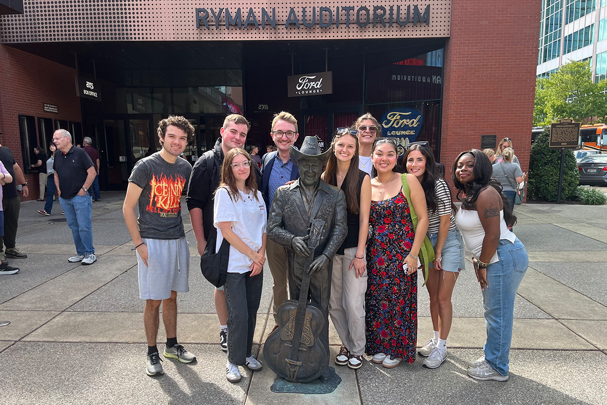 Students posing for group photos at several spots at the Ryman Auditorium.