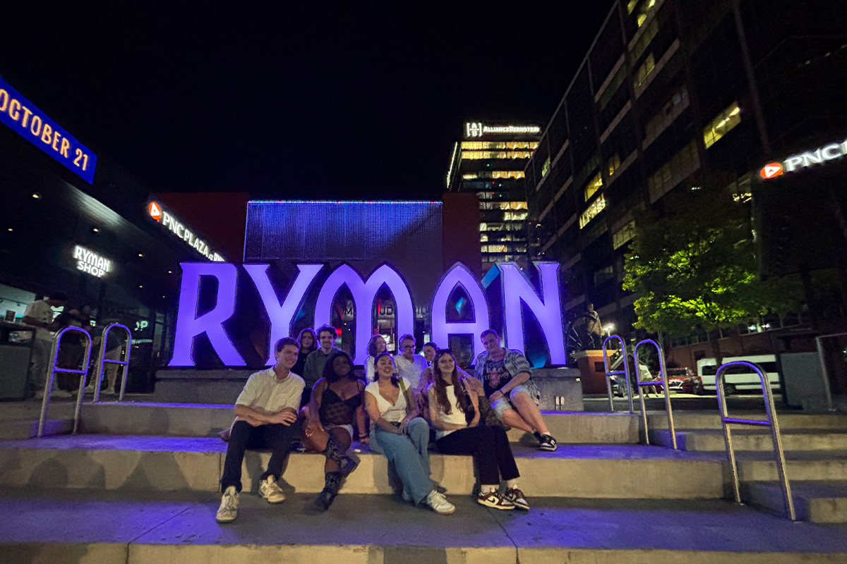 Students posing for group photos at several spots at the Ryman Auditorium.