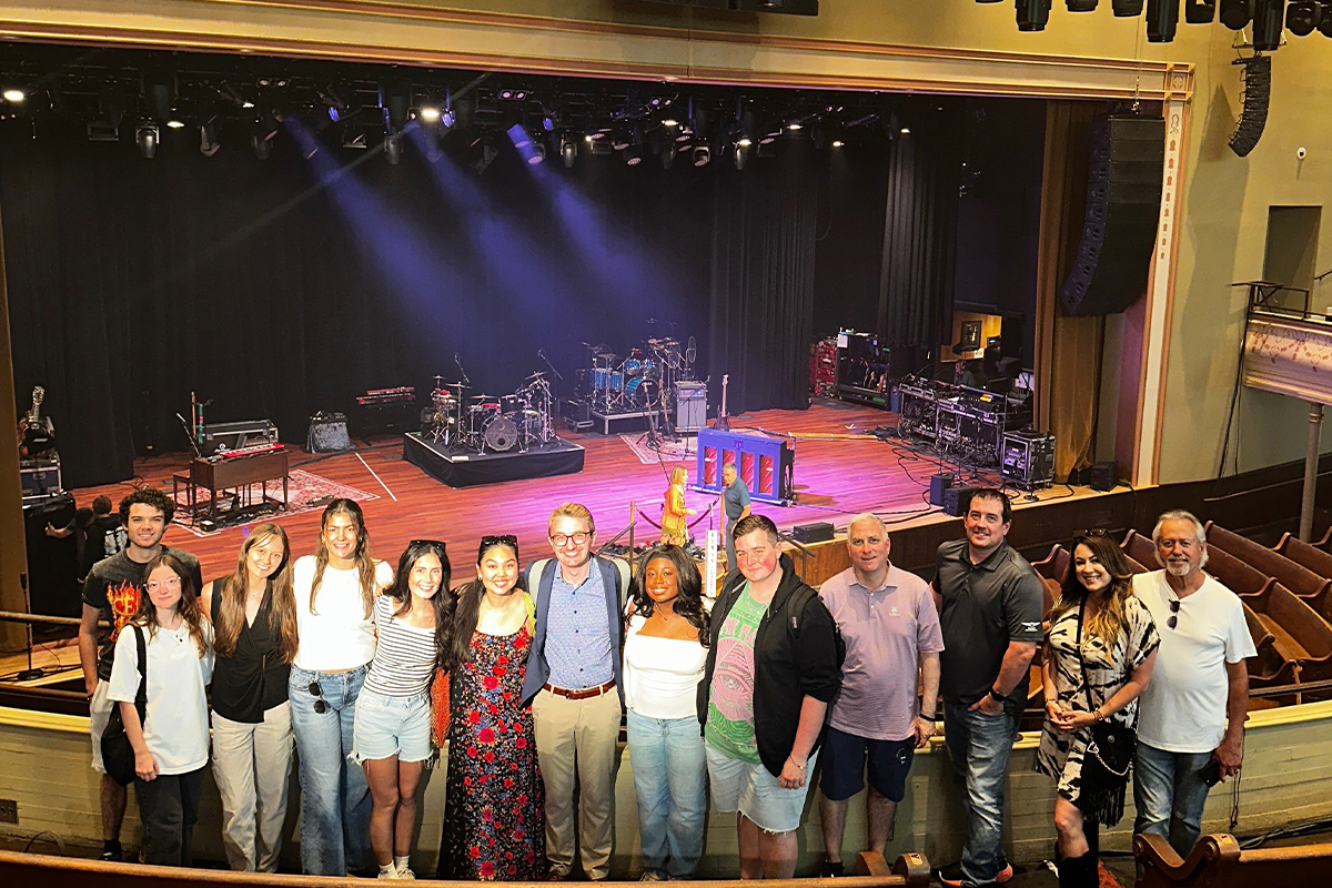 Students posing for group photos at several spots at the Ryman Auditorium.