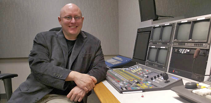 A portrait of Assistant Professor Thomas Baggerman in a campus TV studio control room. | Photo by Leah Irwin