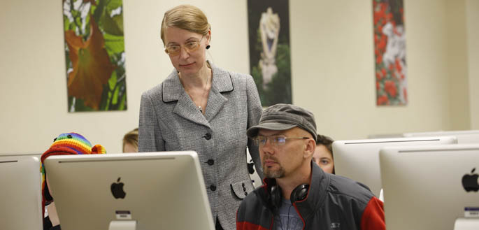 Dr. Tatyana Dumova, associate professor, works with students in a School of Communication graduate class.