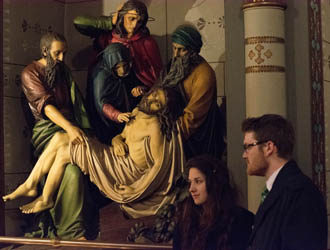 Students Katie Pflug and Zack Durkin stand next<br /> to a statue depicting a scene of the Stations of the Cross during a tour of St. Anthony's Chapel in Troy Hill.