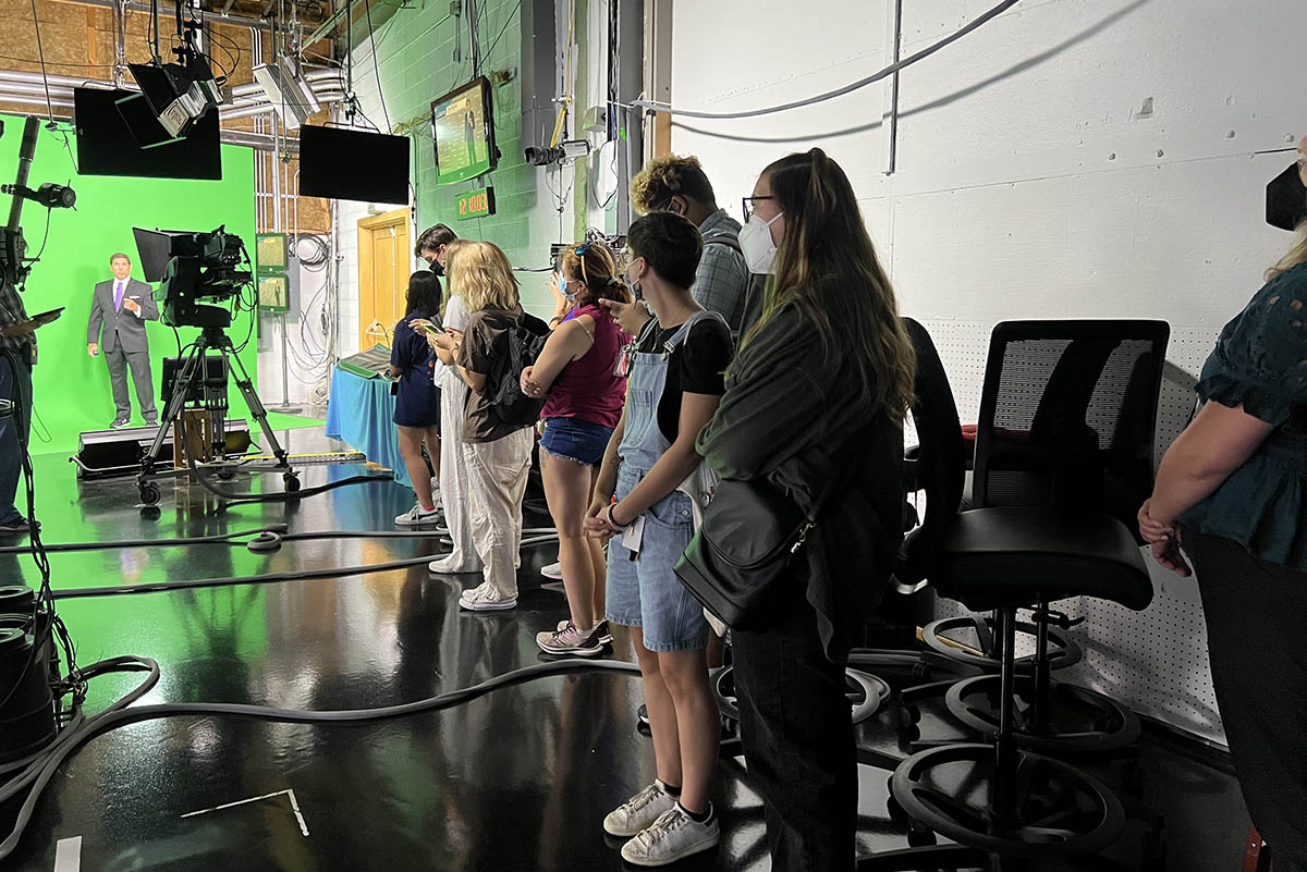 Students watch WTAE Meteorologist Jeff Verszyla do the noon weather report, while across the studio alumna Elena LaQuatra anchors the news.