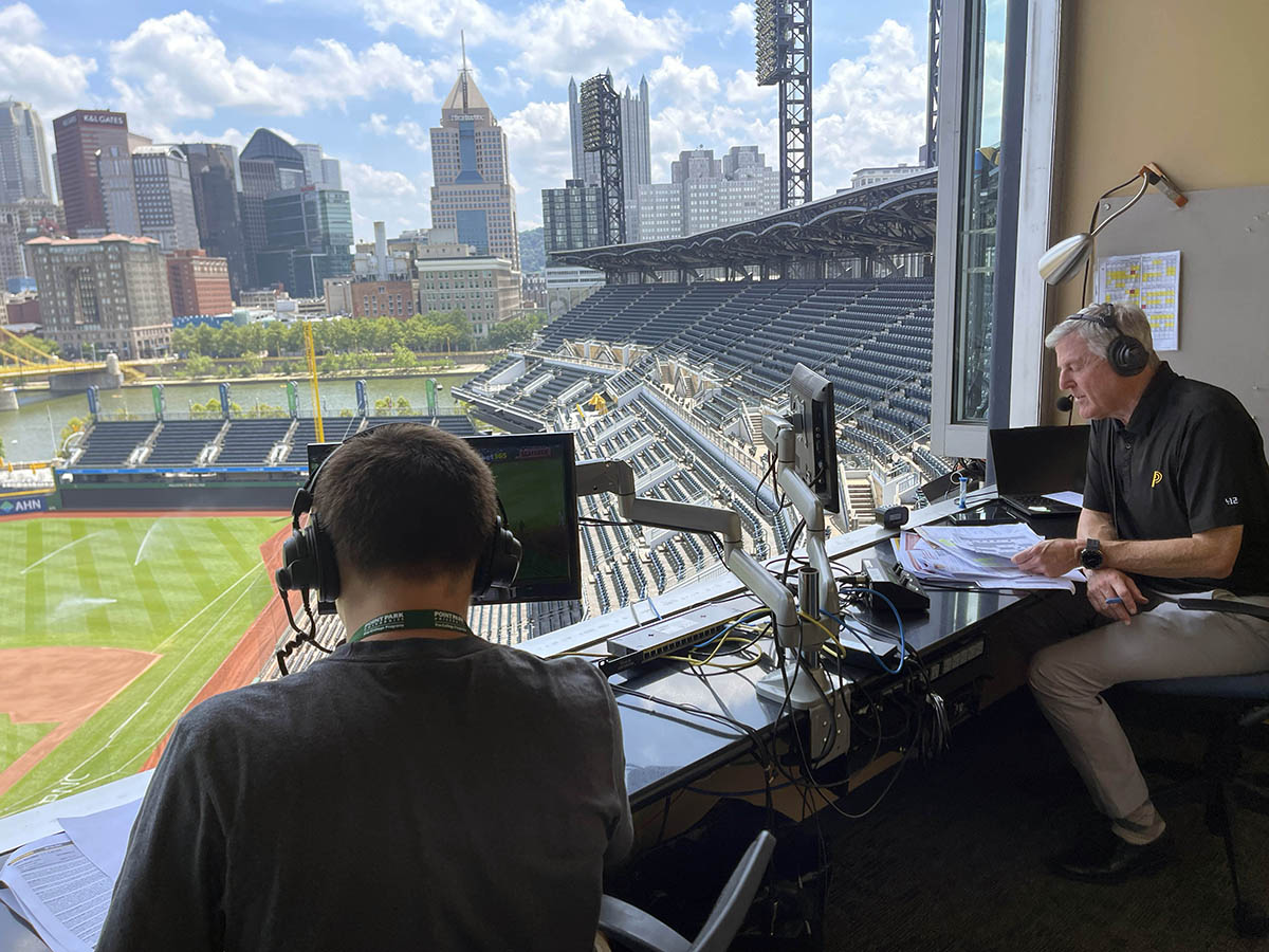 A student gains hands-on experience in the broadcast booth with Greg Brown.  Photo | Paul Koontz
