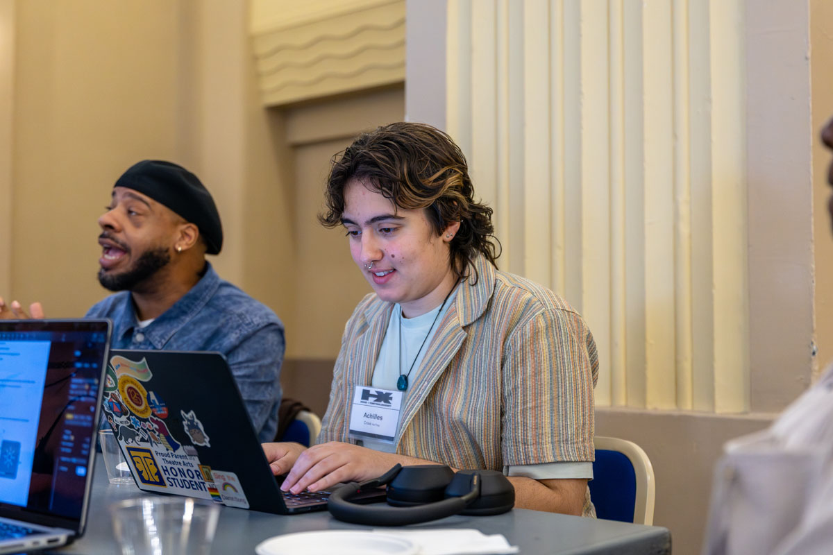 Achilles Cross works on a laptop at the workshop.