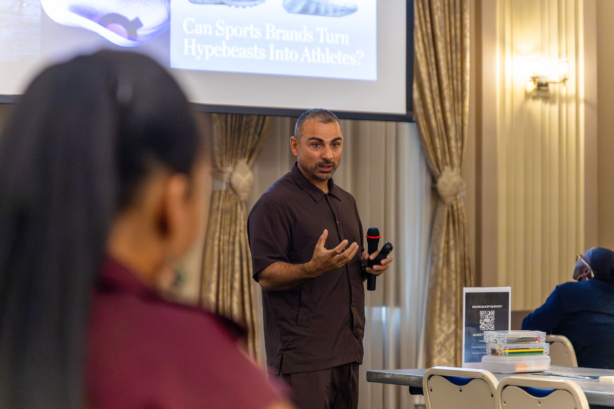 Yassine Saidi speaks into a microphone to students in the ballroom.