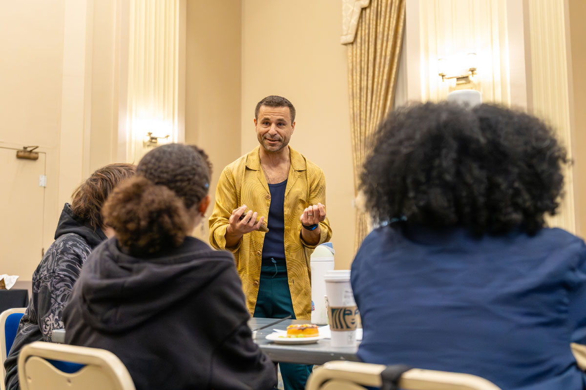 Chris Pandolfi talks with students at a table.