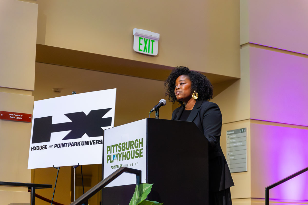 Jasmin DeForrest addresses a crowd from behind a podium.
