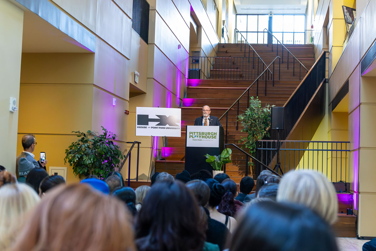 John Montgomery addresses a crowd from behind a podium.