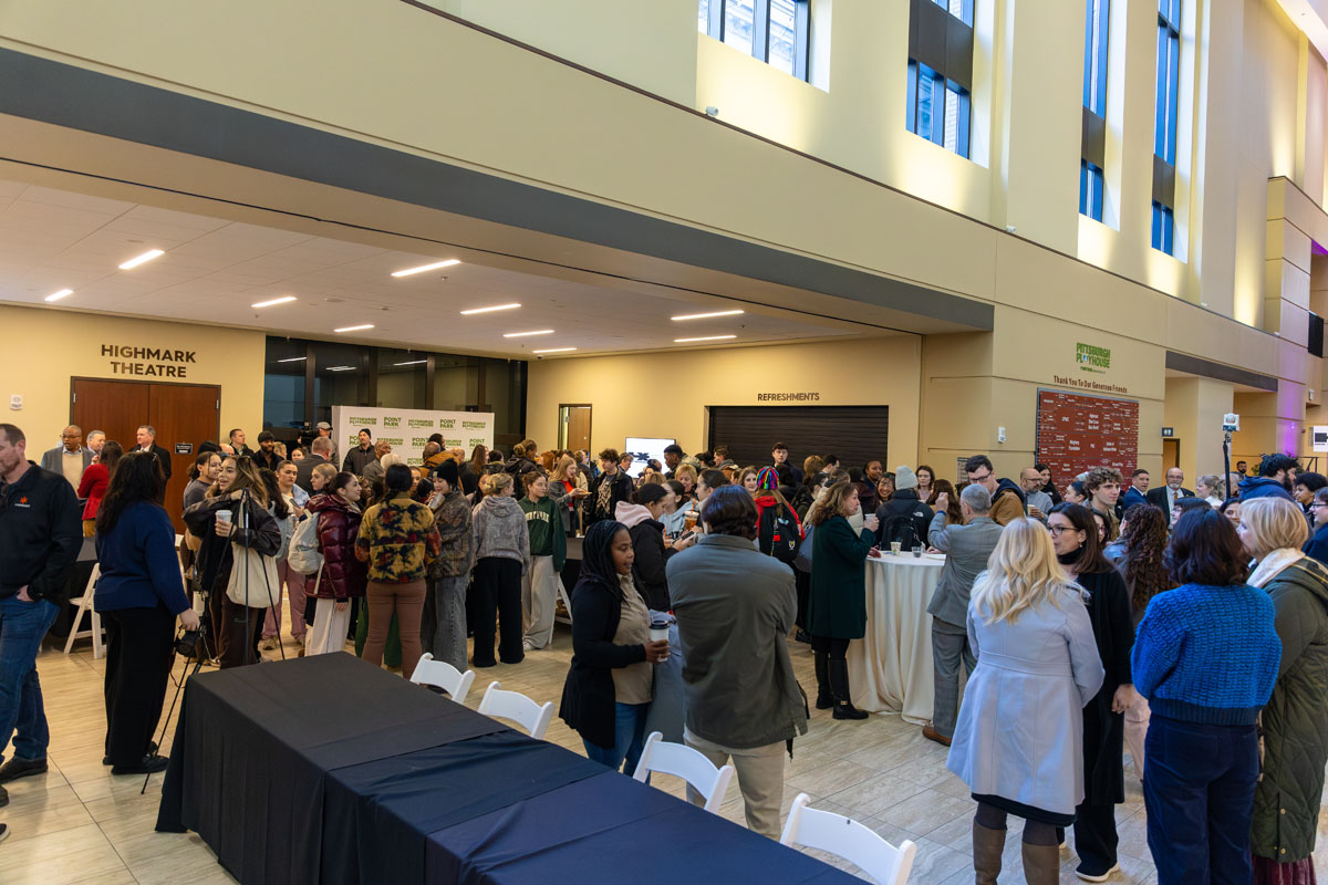A crowd of people stand in the lobby of the Pittsburgh Playhouse.