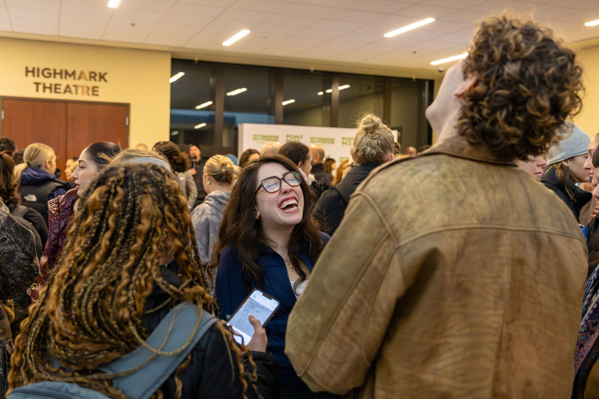 People laugh in the Playhouse lobby.