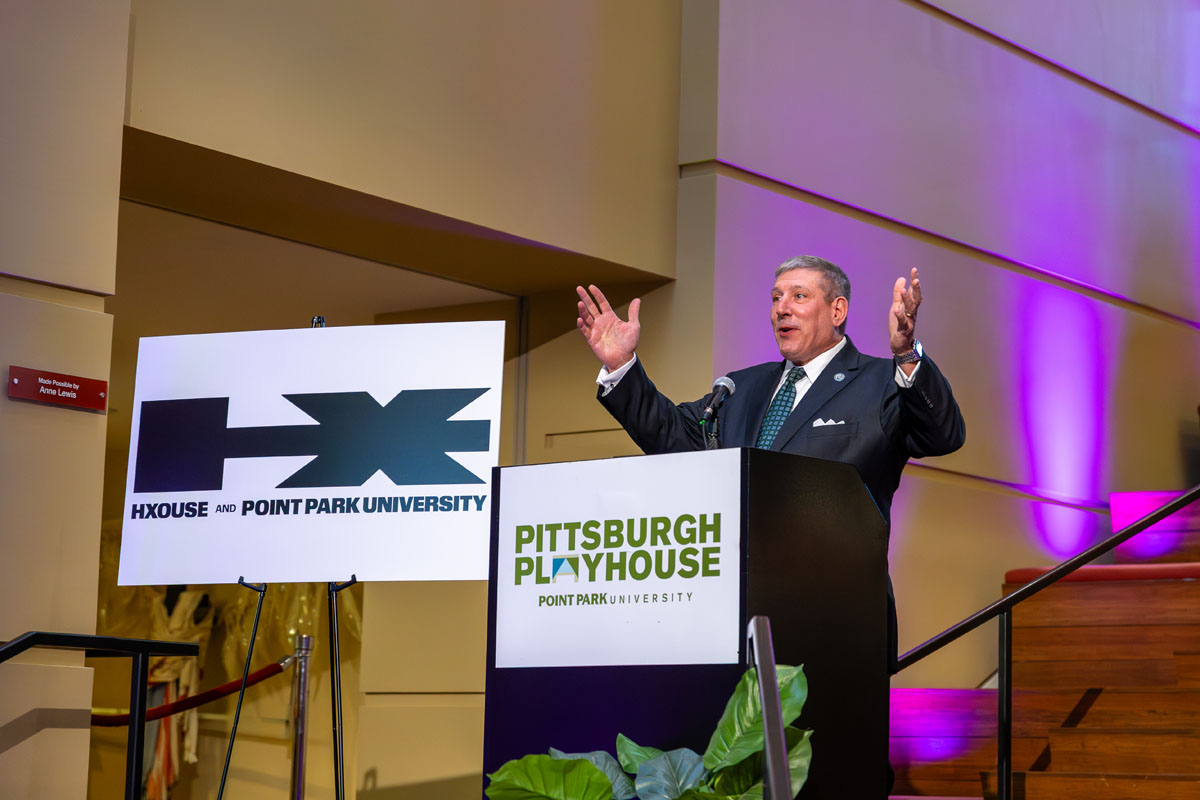 Chris Brussalis addresses a crowd from a podium.