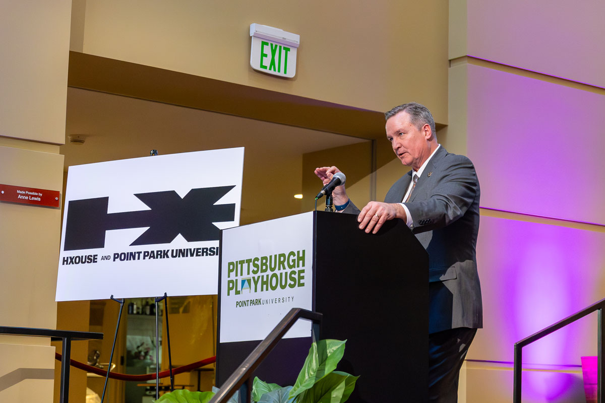 Ted Black speaks to a crowd from a podium.