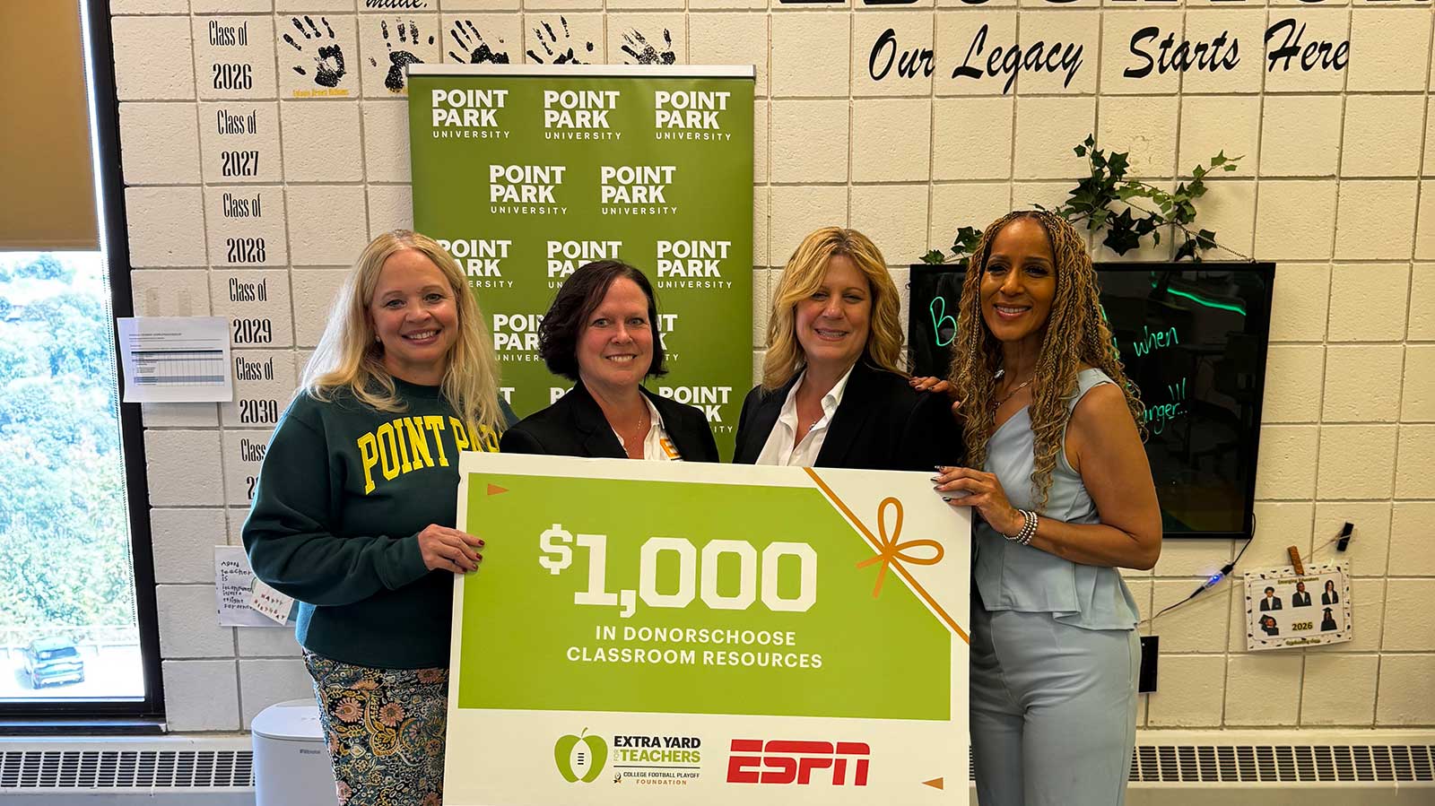 Virginia Chambers stands with staff from Brashear High School holding their award check from ESPN.