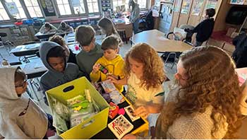 Elementary students select prizes from a cart.