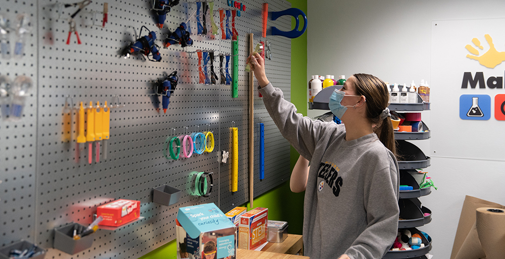 A student selects tools from a peg board in Matt’s Maker Space Lab. Photo by Randall Coleman.
