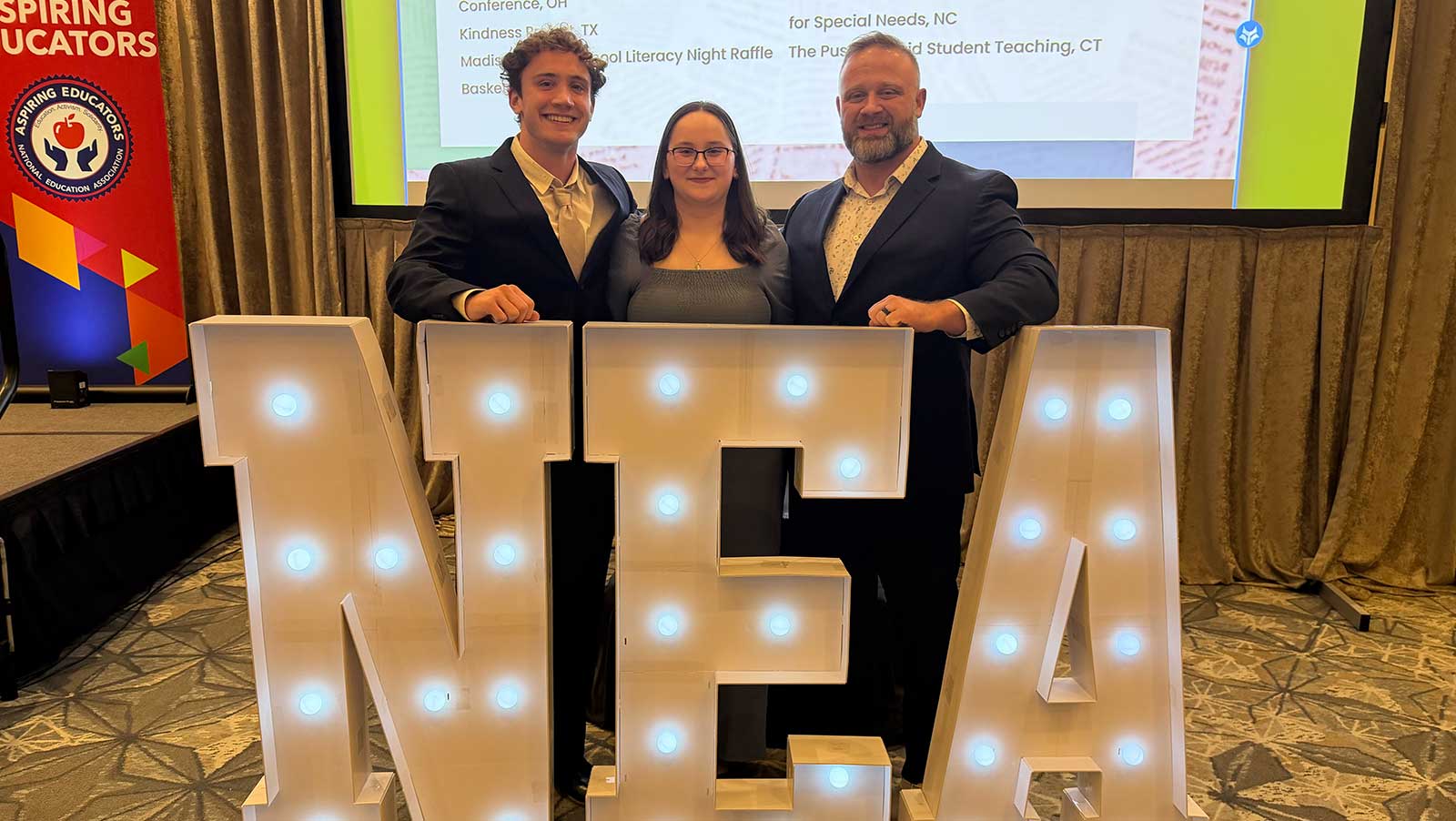 Pictured is Evan Beiter, Lindsey Hoffman and Richard Garris behind the letters N, E, A,