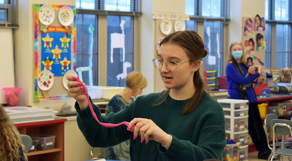 Pictured is Bethani Rechtorik teaching students at Foster Elementary School how to build a friendship pot with clay.