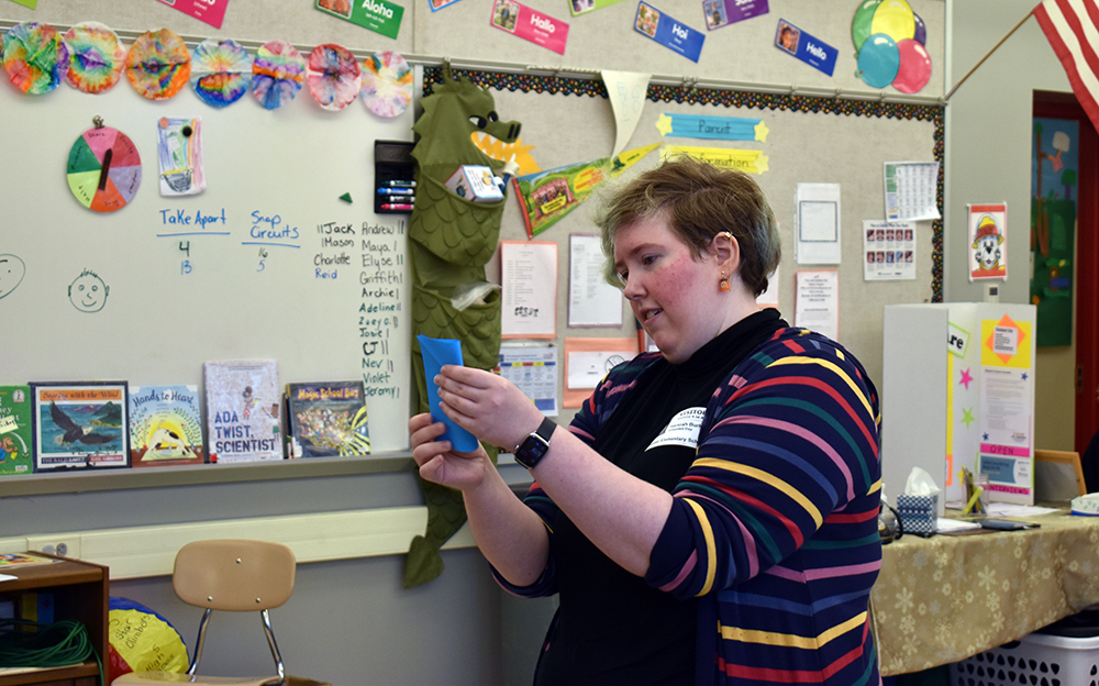 Hannah Burke '23 shows students how to make origami balloons as part of the anger kit from Open the Joy.