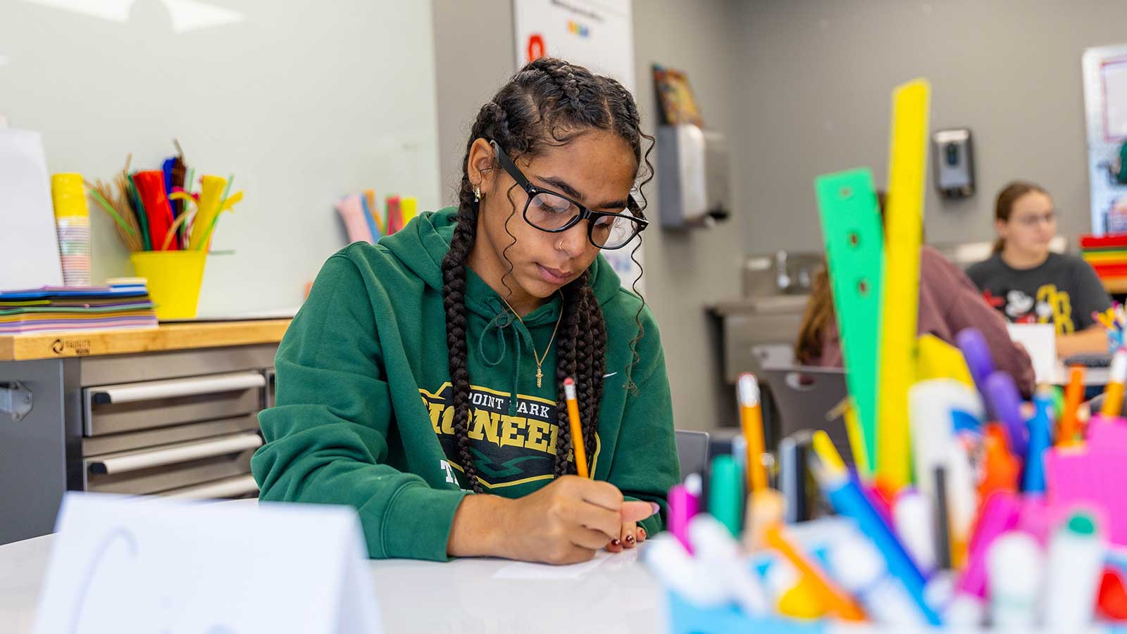 A student works at a desk in the makerspace.