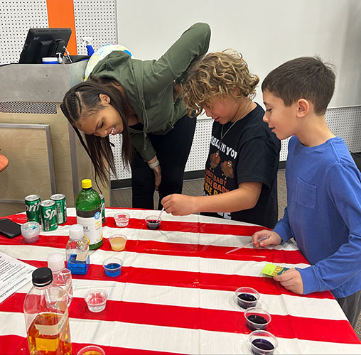 Two education students work with elementary school students.