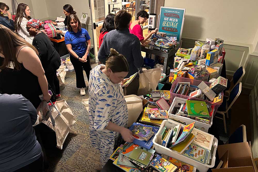 Students select items from tables of books and games.