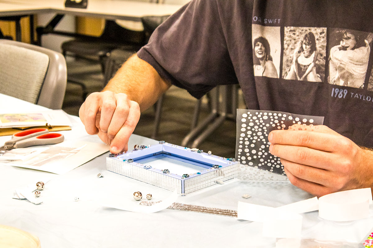 A student decorates a picture frame.