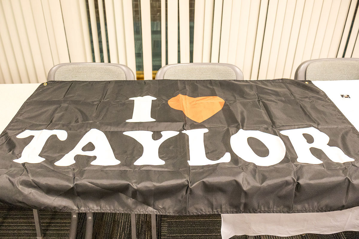 A flag on a table reads "I love Taylor."