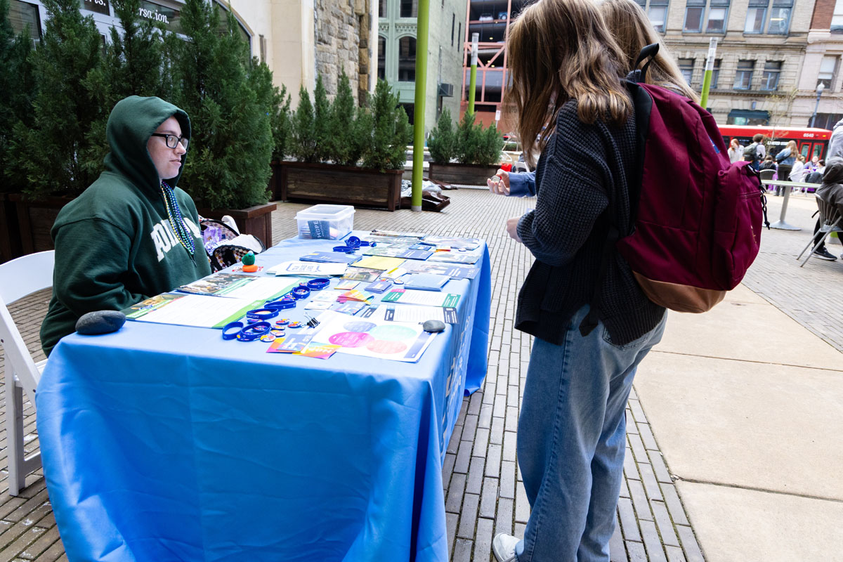 A student visits a table at the Out of the Darkness walk.