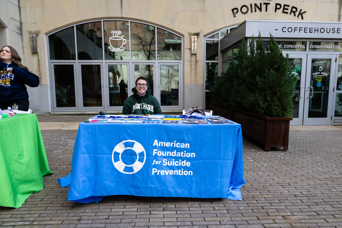 A woman sits at a table for the American Foundation for Suicide Prevention.